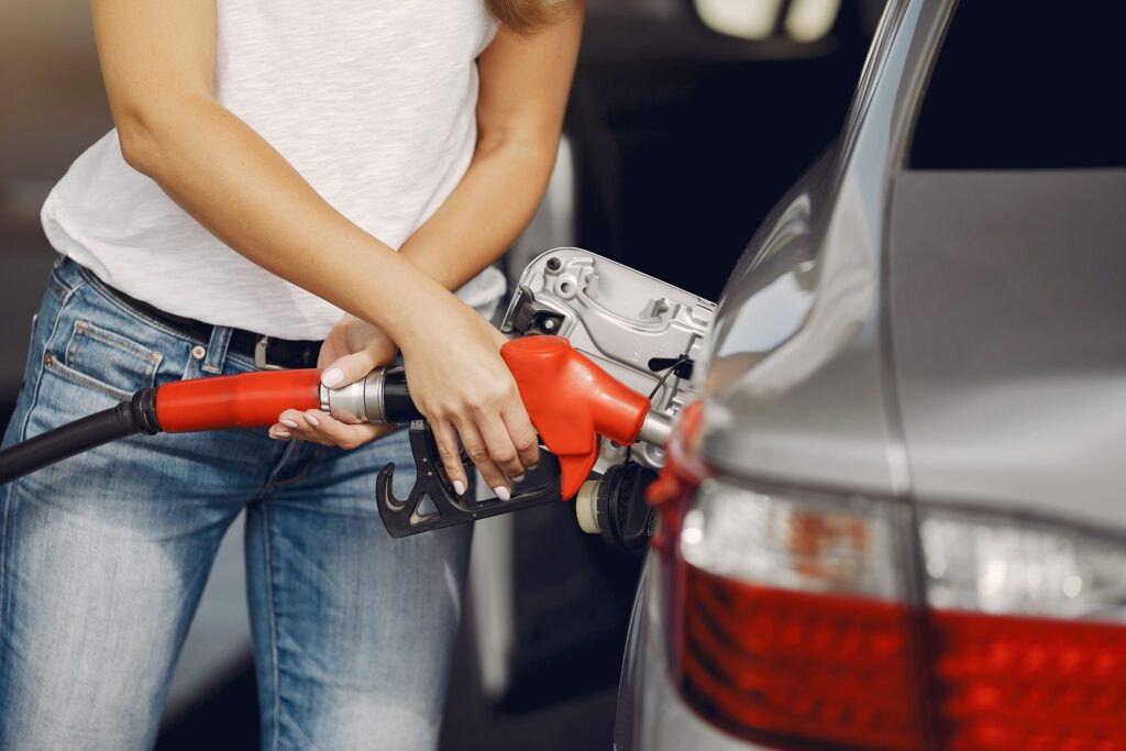 Žena tankuje palivo do stříbrného auta